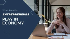 A woman sitting at a desk with a laptop, surrounded by text on the role of entrepreneurs in the economy.